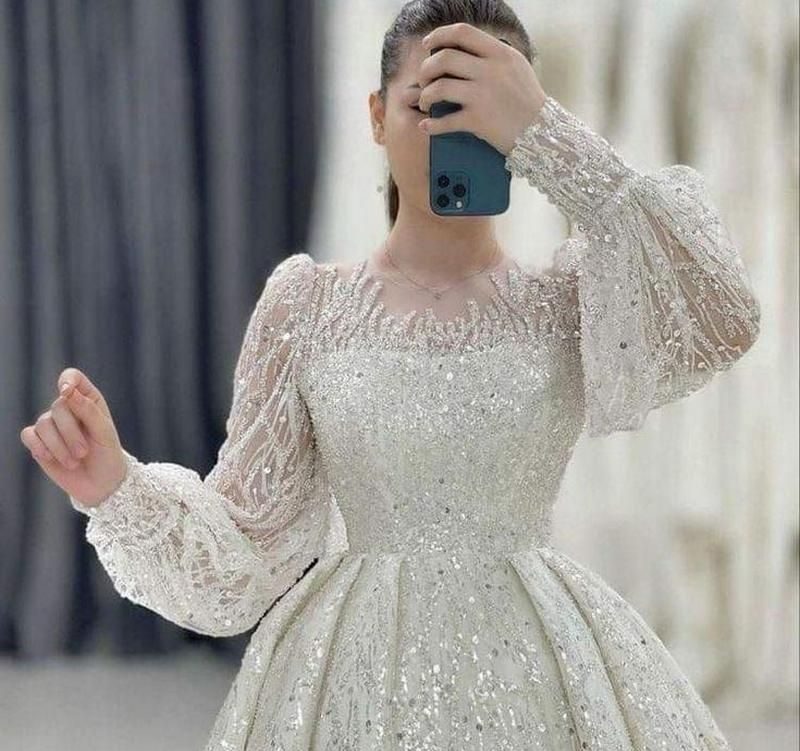 لباس عروس کرهای جدید؛ ۲۲ تصویر از مدلهای ساده، پوشیده و پرنسسی 14 نمای نزدیک لباس عروس با آستین بلند پفی، سرآستین جمع و بالاتنه درخشان